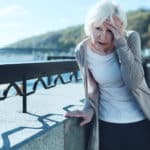 Senior woman having vertigo outdoors